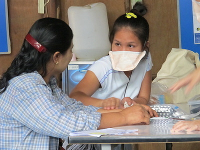 Thailand: Breathe Easy - IOM helps refugees get healthy for resettlement. A child washes down his medicine, a chemoprophylaxis, to prevent TB developing from contact with a family member with active TB at a camp for refugees from Myanmar in Northern Thailand. © IOM 2012