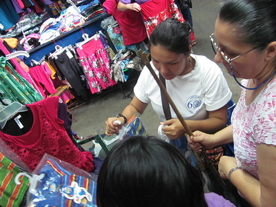 IOM Project Assistant, Tatiana Ortiz, accompanies a beneficiary to make initial purchases for her new clothing business.
