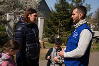 IOM staff discussing with Kateryna Bagoditna, 37, a beneficiary of multipurpose, cash-based IOM assistance. At the start of the war, Kateryna and her family were woken by the sound of shelling, uprooted from her family home in the northern Ukrainian city of Shostka, Sumy Region, Kateryna arrived in Uzhhorod, western Ukraine.