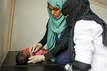 An IOM’s health team member provides primary health care services to a newborn child at the Al Yabli Health Center on Yemen’s West Coast. © IOM 2022/Majed MOHAMMED