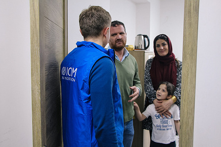 IOM staff talks with a family from Afghanistan accommodated at a hostel. Â© IOM 2023 / Hanna Kalichava
